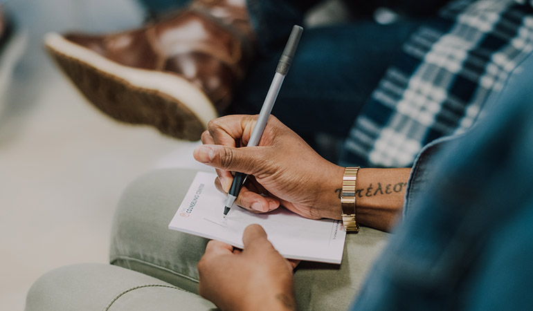 a man writing notes in a group session