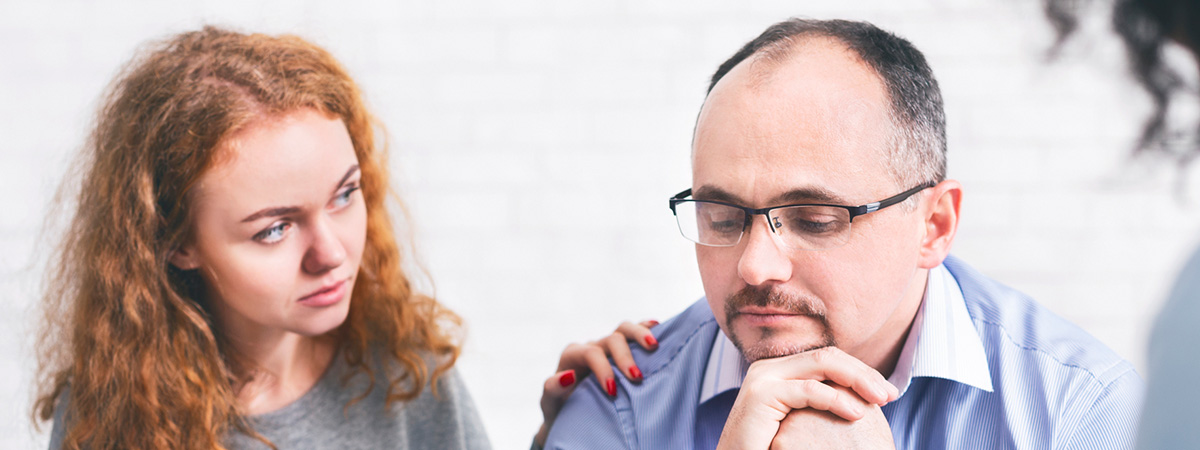  Supportive wife comforting husband with TRD during a meeting with a counselor in Freehold.